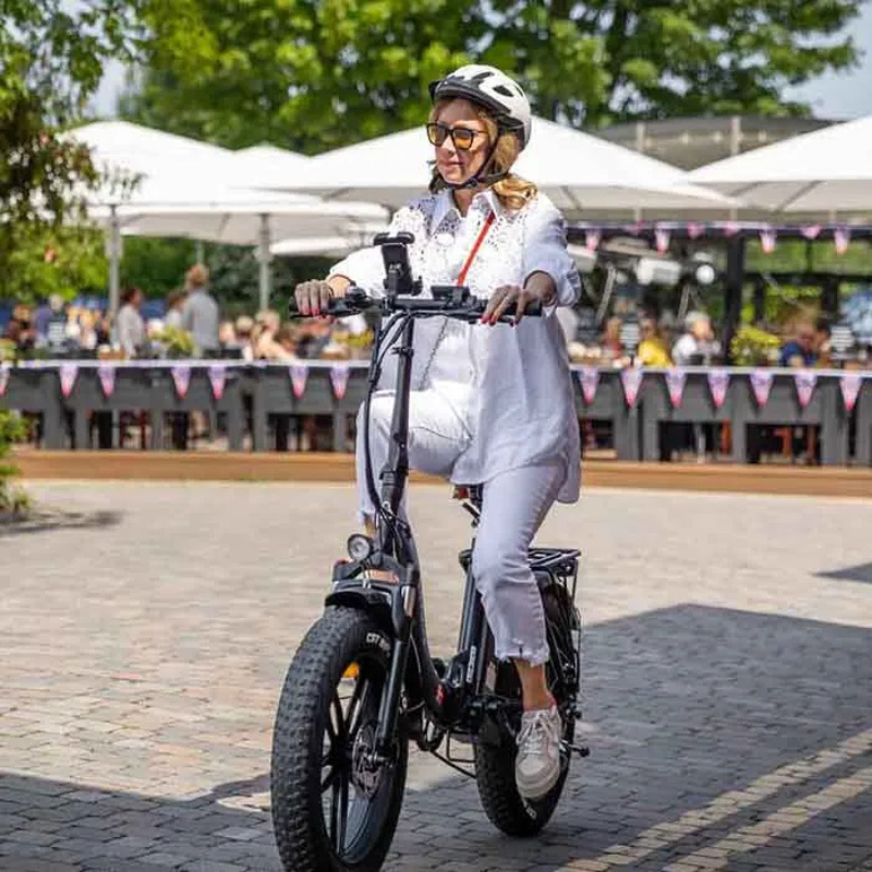 lady in white riding Hygge Vester Step on cobble path in summer