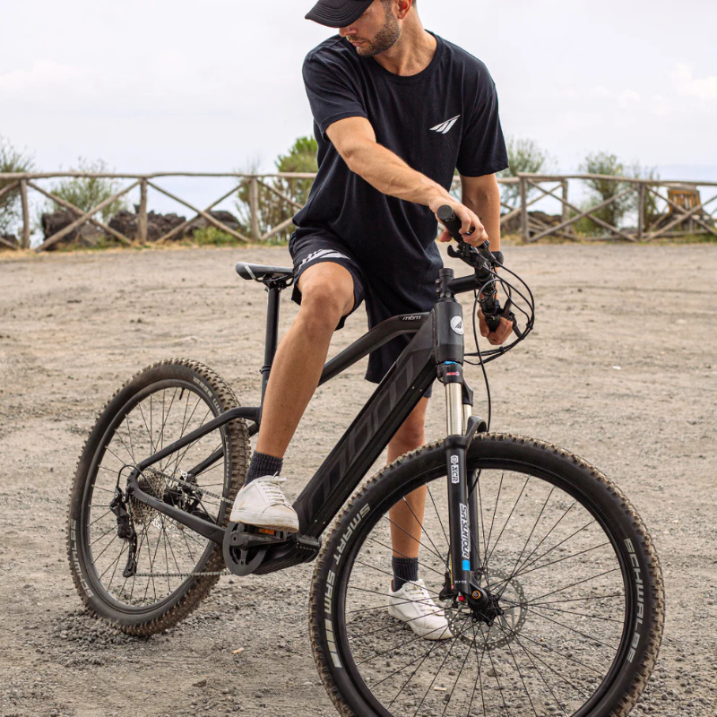 MBM Kairos Electric Mountain Bike ridden by man with beard and cap on gravel
