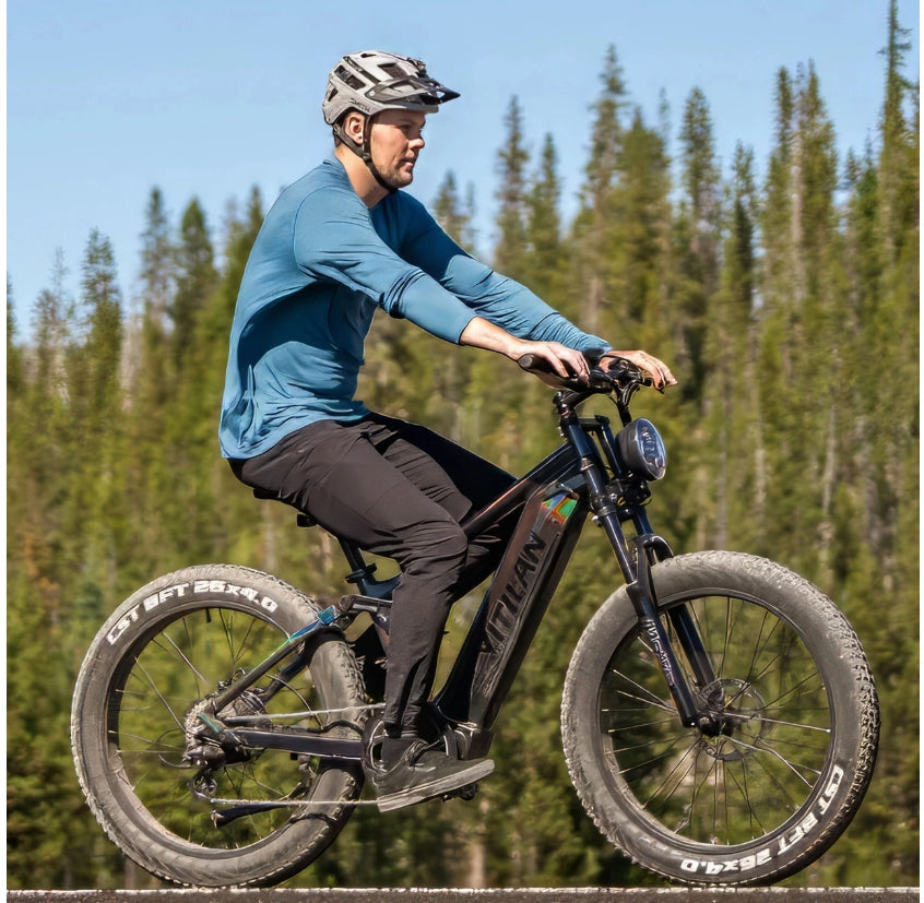 Man doing a wheelie on a green Engwe EP-2 3.0 Boost Fat Tyre E-Bike on a trail in the forest