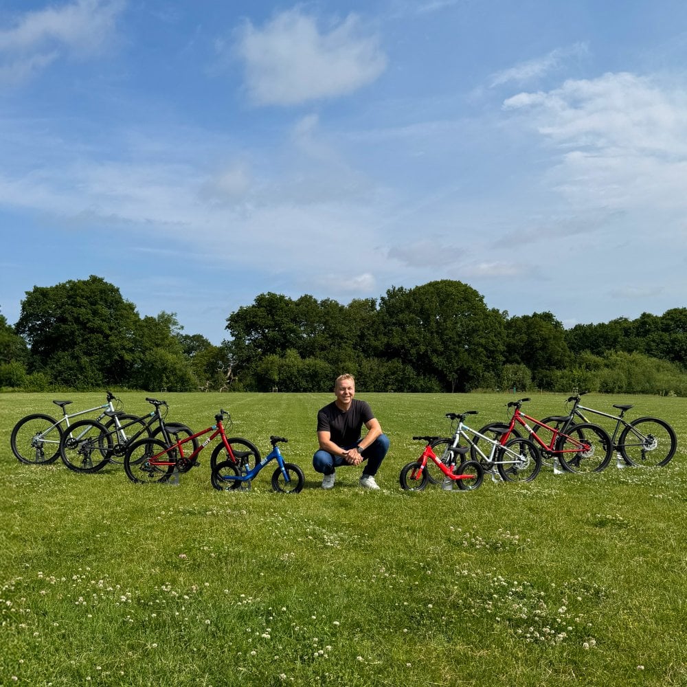 HOY kids bikes collection featuring eight lightweight children’s bikes with Sir Chris Hoy in a field
