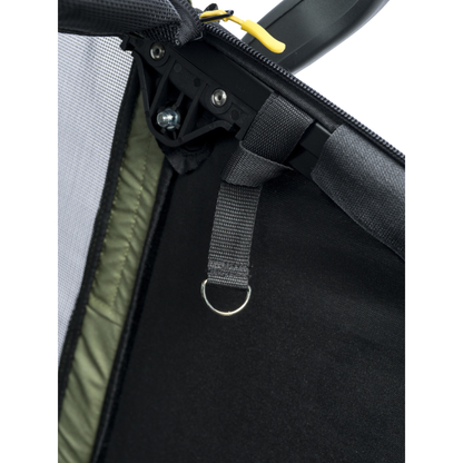 Close-up detail of a black mesh and fabric pet carrier or bag, showing a black zipper track, black webbing strap with a metal D-ring, olive green interior lining, and a small yellow zipper pull on a white background.